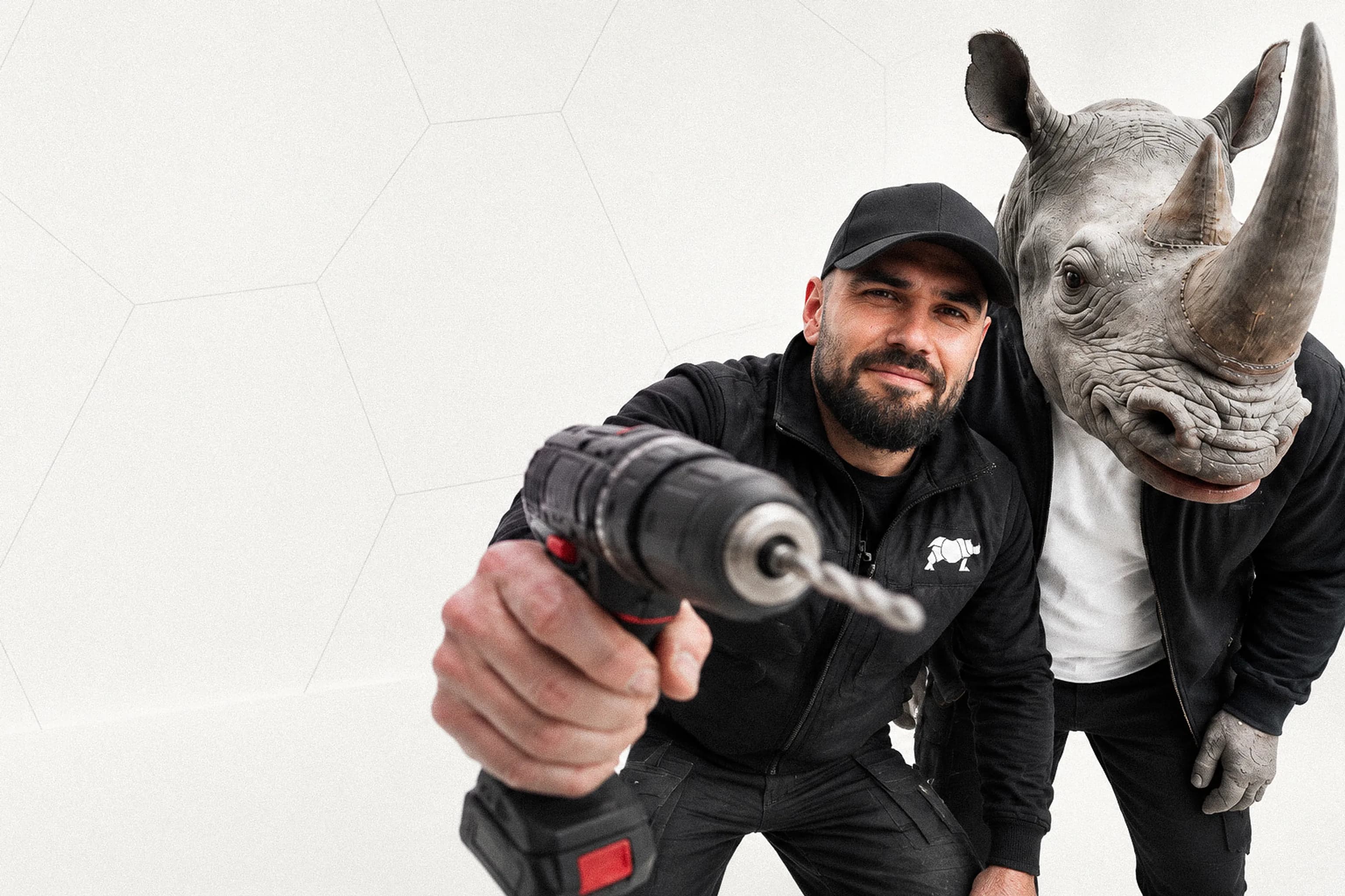 Programme secteur bâtiment : un professionnel tend sa perceuse vers l’objectif, à côté d’un personnage à tête de rhinocéros